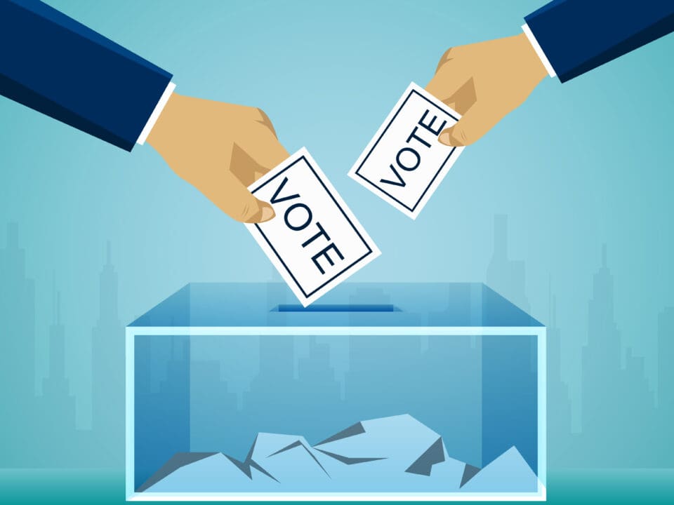 Image of two hands placing votes in a box